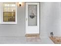 Inviting entryway featuring a bright white front door with decorative wreath and a sidelight window at 1420 Oak Hill Dr # 102, Dunedin, FL 34698