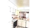 Bright kitchen features classic white cabinets and appliances, offering a cozy and functional space at 1420 Oak Hill Dr # 102, Dunedin, FL 34698