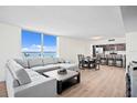 Open living area with water views, a plush sofa, and a seamless flow to the dining and kitchen at 1430 Gulf Blvd # 603, Clearwater Beach, FL 33767
