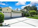 Well-maintained home with a three-car garage and neatly manicured landscaping at 18951 Grand Club Dr, Hudson, FL 34667