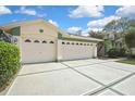 Spacious three-car garage with decorative windows and ample parking on the concrete driveway at 18951 Grand Club Dr, Hudson, FL 34667
