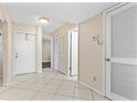 Bright hallway features neutral paint, tile flooring, closet doors, and entry to other rooms at 2073 Skimmer W Ct # 211, Clearwater, FL 33762