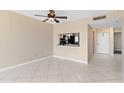Open living space with tile flooring, a ceiling fan, and a pass-through to the kitchen at 2073 Skimmer W Ct # 211, Clearwater, FL 33762