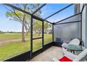 Enclosed porch featuring a scenic view of a lush golf course and outdoor seating at 2073 Skimmer W Ct # 211, Clearwater, FL 33762