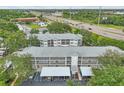 Aerial view of a multi-story condo building with mature trees and a highway nearby at 21103 Patio View Ct # 3305, Lutz, FL 33558