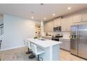 Modern kitchen with gray cabinets, stainless steel appliances, and a quartz countertop island at 2334 Audubon Preserve Ln, Lutz, FL 33558