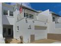 Exterior of townhome featuring a garage, white paint, and an American flag on the balcony at 2985 W Knights Ave # 2985, Tampa, FL 33611