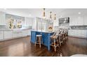 Spacious kitchen with white cabinets, contrasting island, marble counters, and pendant lighting at 3412 W Mckay Ave, Tampa, FL 33609
