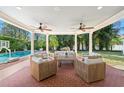 Inviting covered patio with brick flooring, ceiling fans, and comfortable seating near the pool at 3412 W Mckay Ave, Tampa, FL 33609