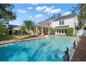 Backyard pool with brick trim, covered porch and exterior views of home at 3412 W Mckay Ave, Tampa, FL 33609