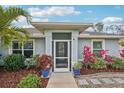 Inviting front entrance with a screened porch, colorful landscaping, and stone pathway at 3655 Candia Ave, North Port, FL 34286