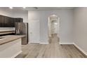 Open-concept living space with laminate wood flooring, white walls, and entry to kitchen at 518 Glenn Cross Dr, Ruskin, FL 33570