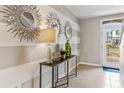 A welcoming entryway table with decor and sunlight streaming through the glass front door at 5233 Salt Marsh Rd, Wimauma, FL 33598