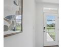 Bright entryway with decorative art, a security system, and glass paneled front door at 5324 Berry Bay Ave, Wimauma, FL 33598