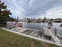 Waterfront view highlighting a dock with boat lift and canal views of surrounding homes at 5360 Windward Way, New Port Richey, FL 34652