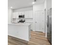 Bright kitchen features white cabinetry, stainless appliances, and center island at 5588 Delight Ave, North Port, FL 34288