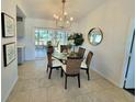 Cozy dining area with a glass table, chandelier, and sliding glass doors to the lanai at 6707 Thorman Rd, Port Charlotte, FL 33981