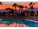 Community pool at sunset with palm trees and building reflections in the water at 7310 Sunshine Skyway S Ln # 219, St Petersburg, FL 33711