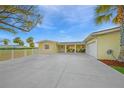 Charming yellow home with a spacious driveway, attached garage and lush landscaping at 8841 W Millpoint Rd, Riverview, FL 33578