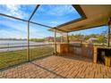 Outdoor kitchen under covered patio that is perfect for grilling and waterfront entertainment at 8841 W Millpoint Rd, Riverview, FL 33578