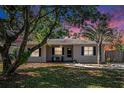 Charming home with lush landscaping, mature trees, shutters, and colorful sunset at 917 2Nd Nw Ave, Largo, FL 33770
