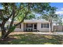 Well-kept single-story home featuring a lush lawn, mature trees, and a tidy facade at 917 2Nd Nw Ave, Largo, FL 33770