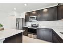 Stylish kitchen with dark cabinetry, stainless steel appliances, quartz countertops, and recessed lighting at 12823 Wanderlust Pl, Parrish, FL 34219