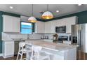 Modern kitchen featuring white cabinets, stainless steel appliances, and a center island with seating at 12823 Wanderlust Pl, Parrish, FL 34219