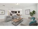 Bright, open-concept living room showcases stylish furniture and seamless transition to a modern kitchen and dining area at 12823 Wanderlust Pl, Parrish, FL 34219