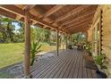 Spacious wooden porch perfect for relaxing, with ample seating and views of the surrounding greenery at 14206 Walden Sheffield Rd, Dover, FL 33527
