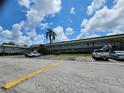 Condo community featuring two-story buildings, palm trees, and assigned parking at 1433 S Belcher Rd # A12, Clearwater, FL 33764