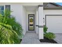 Inviting front porch with decorative accents and a view of the manicured landscaping at 1848 Sunset Preserve Way, Port Charlotte, FL 33953
