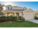 Two-story home featuring a well-manicured lawn and a two-car garage with beautiful stone accents at 19122 Sunset Bay Dr, Land O Lakes, FL 34638