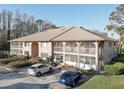Beige condo building with well-maintained landscaping and visible parking at 3200 Charter Club Dr # A1, Tarpon Springs, FL 34688