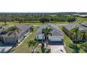 An aerial view showing the neighborhood, with lush landscaping, mature trees, and neighboring homes at 328 Siena Vista Pl, Sun City Center, FL 33573