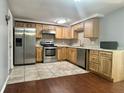 Bright kitchen with wooden cabinets, stainless steel appliances, tile backsplash, and granite countertops at 3453 Garfield Dr, Holiday, FL 34691