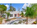 Inviting single-Gathering home with a textured stucco exterior, vibrant orange accents, and lush landscaping at 4827 7Th N Ave, St Petersburg, FL 33713