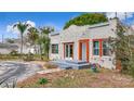 Cozy single-story home featuring a stucco exterior, eye-catching orange window trim, and a quaint front yard at 4827 7Th N Ave, St Petersburg, FL 33713