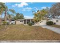 Well-kept single-story residence boasting a curved screened porch and a lush green lawn at 5317 Tammy Ln, Holiday, FL 34690