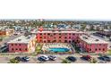 Exterior view of an apartment complex with a courtyard pool, lounge chairs, and covered patios at 6800 Sunset Way # 1003, St Pete Beach, FL 33706