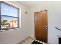 Hallway view of an apartment entrance, numbered 1003, with a beach view through the window at 6800 Sunset Way # 1003, St Pete Beach, FL 33706