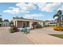 Inviting single-story home with screen enclosed porch, pretty landscaping and two Adirondack chairs at 829 E 4Th St, Englewood, FL 34223