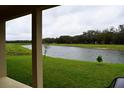 Serene backyard view overlooking a tranquil pond and lush green space, offering a peaceful retreat at 8438 Wheat Stone Dr, Zephyrhills, FL 33540