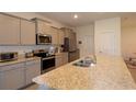 Modern kitchen featuring granite countertops, stainless steel appliances, and ample cabinet space at 8438 Wheat Stone Dr, Zephyrhills, FL 33540