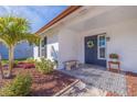 Inviting front porch with patterned tile, a bench and a manicured garden at 10042 85Th St, Seminole, FL 33777