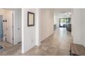 Bright hallway with tile flooring leading to the living area and a bathroom on the left at 10604 Scenic Hollow Dr, Riverview, FL 33578
