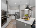 Modern kitchen featuring white cabinetry, stainless steel appliances, a central island, and elegant pendant lighting at 13532 Haflinger Way, Hudson, FL 34667