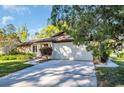 Charming single-story home with stone accents, a well-manicured lawn, and a two-car garage at 1434 Glengarry Dr, Palm Harbor, FL 34684