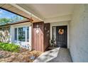 Inviting front entry with decorative wreath, wood accents, and tiled porch at 1434 Glengarry Dr, Palm Harbor, FL 34684