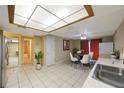 Eat-in kitchen with white cabinets, tile floor, and view to the bathroom and hallway at 15530 Morgan St, Clearwater, FL 33760
